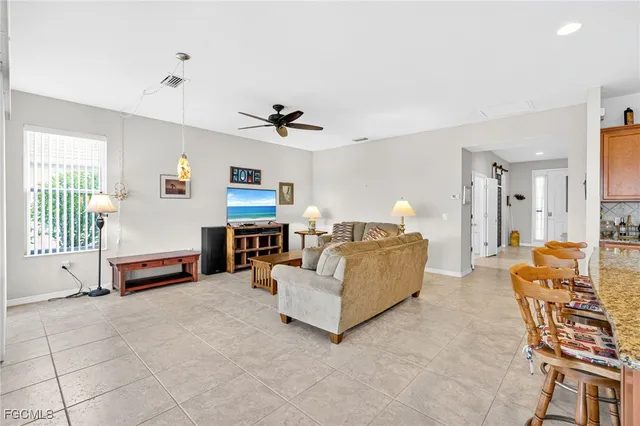 a living room with furniture and a view of kitchen