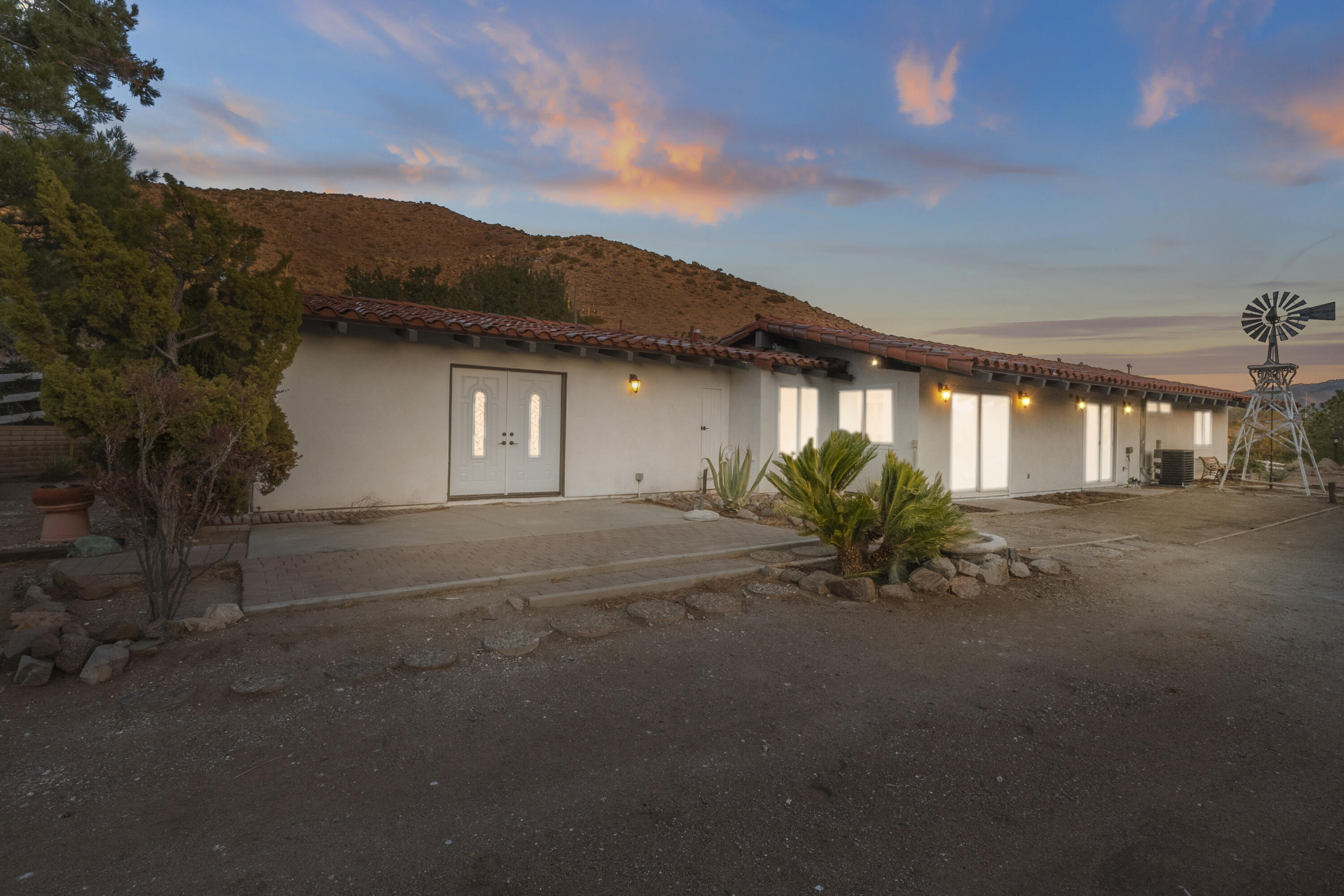 a white house with a flower garden in front of it