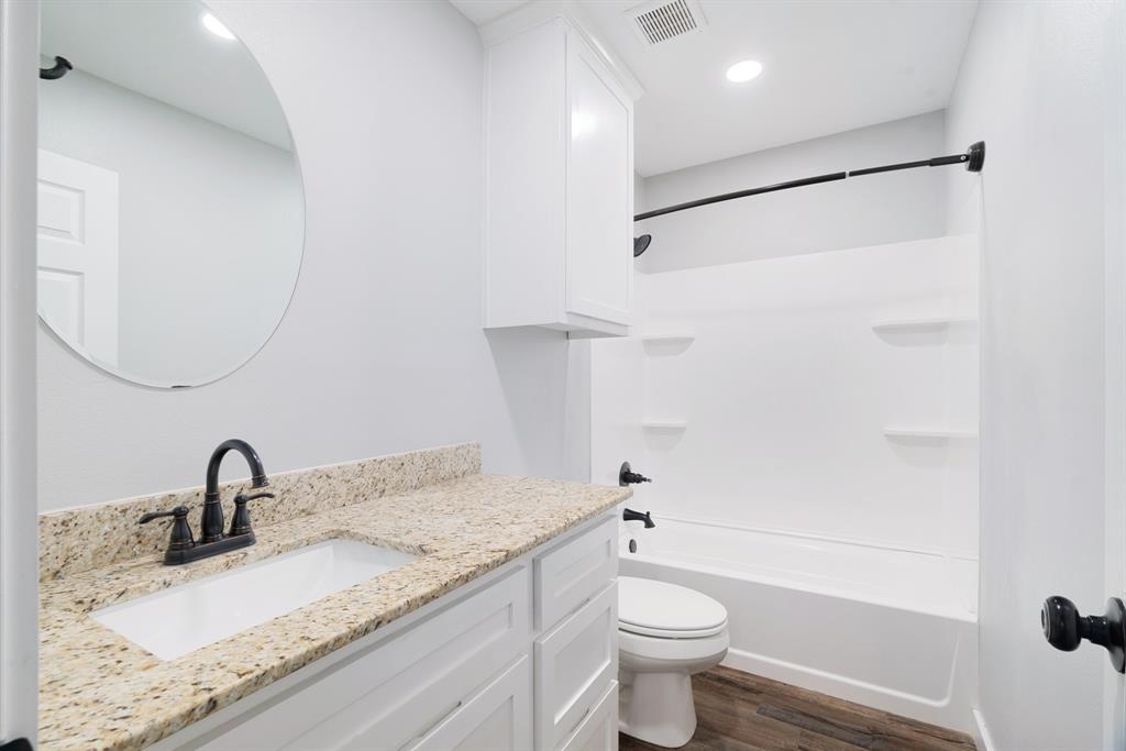 19 Private Road Paris, TX 75460 - Photo 16 of 18 a bathroom with a granite countertop sink a toilet and a mirror