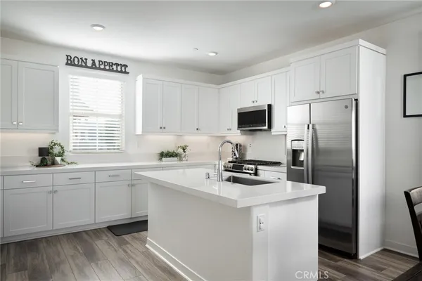 a kitchen with appliances a sink cabinets and a window