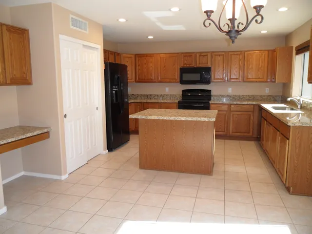 a kitchen with stainless steel appliances granite countertop a refrigerator and a stove top oven