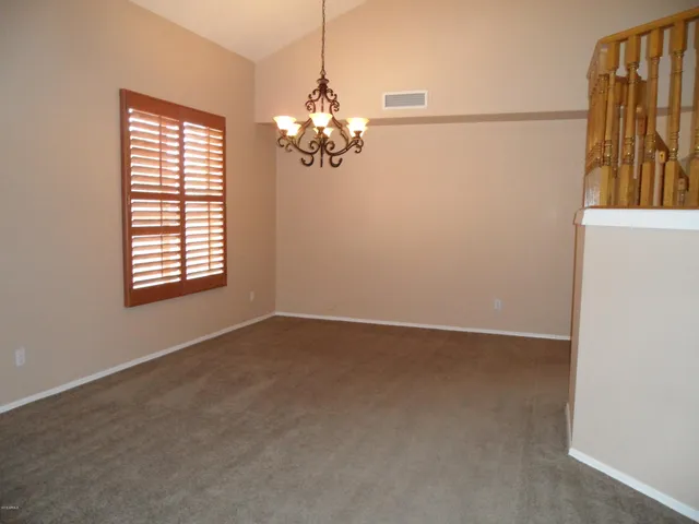 an empty room with windows and chandelier