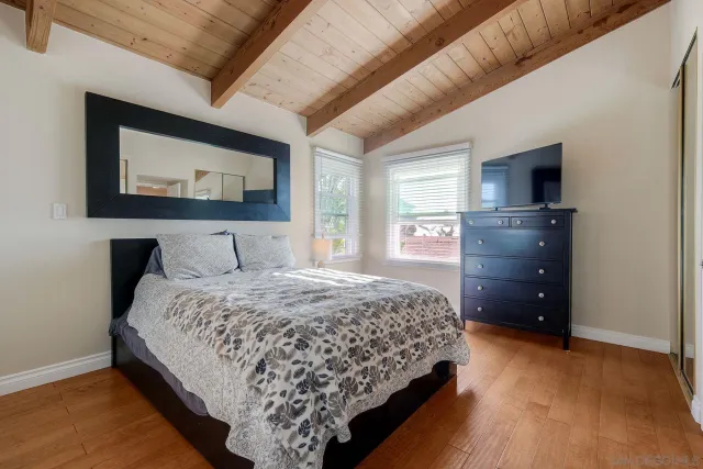 a bedroom with bed and wooden floor