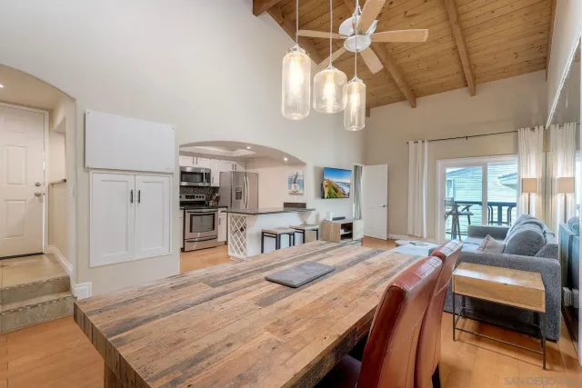 a dining room with wooden floor a chandelier a wooden table and chairs