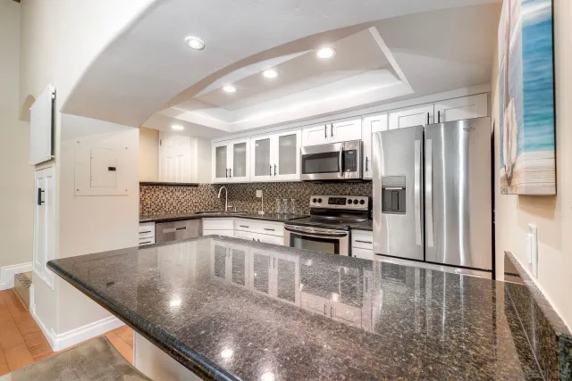 a kitchen with stainless steel appliances granite countertop a refrigerator a stove top oven a sink with granite countertops and cabinets