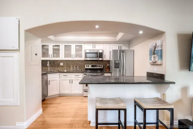 a kitchen with stainless steel appliances granite countertop a stove and a refrigerator