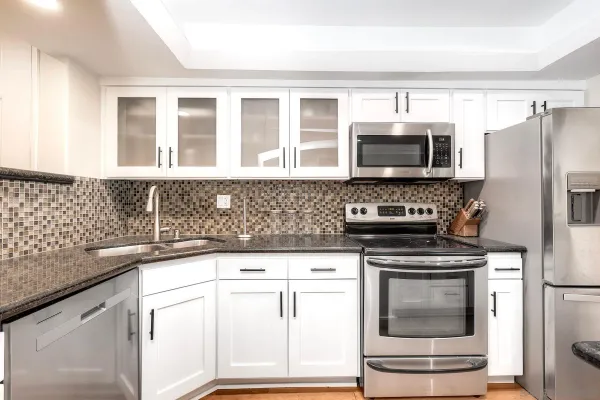 a kitchen with granite countertop a sink stove and microwave