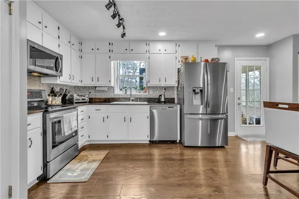 a kitchen with a sink a refrigerator and cabinets