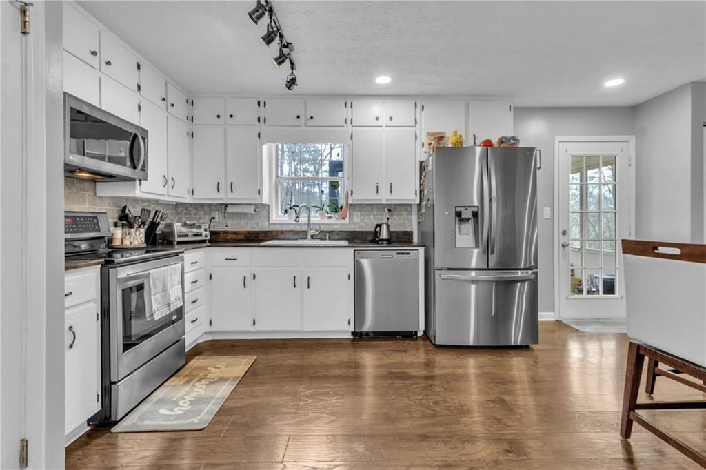 3123 Booths Court Dacula, GA 30019 - Photo 11 of 56 a kitchen with a sink a refrigerator and cabinets
