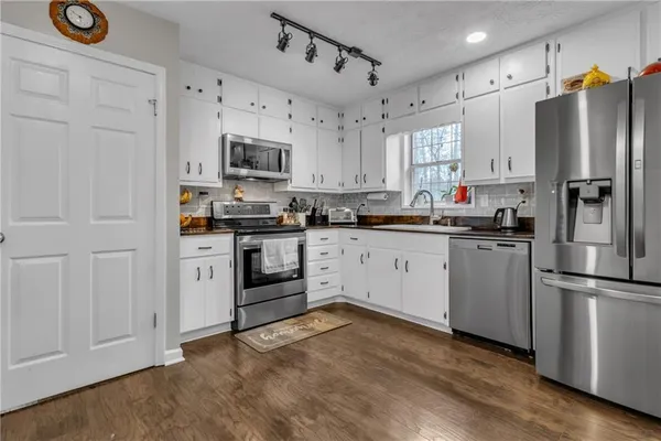 a kitchen with stainless steel appliances a refrigerator sink and cabinets