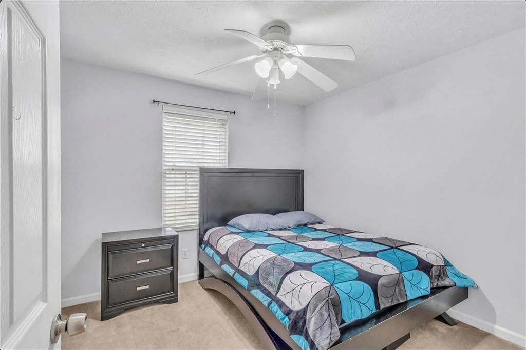 3123 Booths Court Dacula, GA 30019 - Photo 17 of 56 a bedroom with a bed and a chandelier