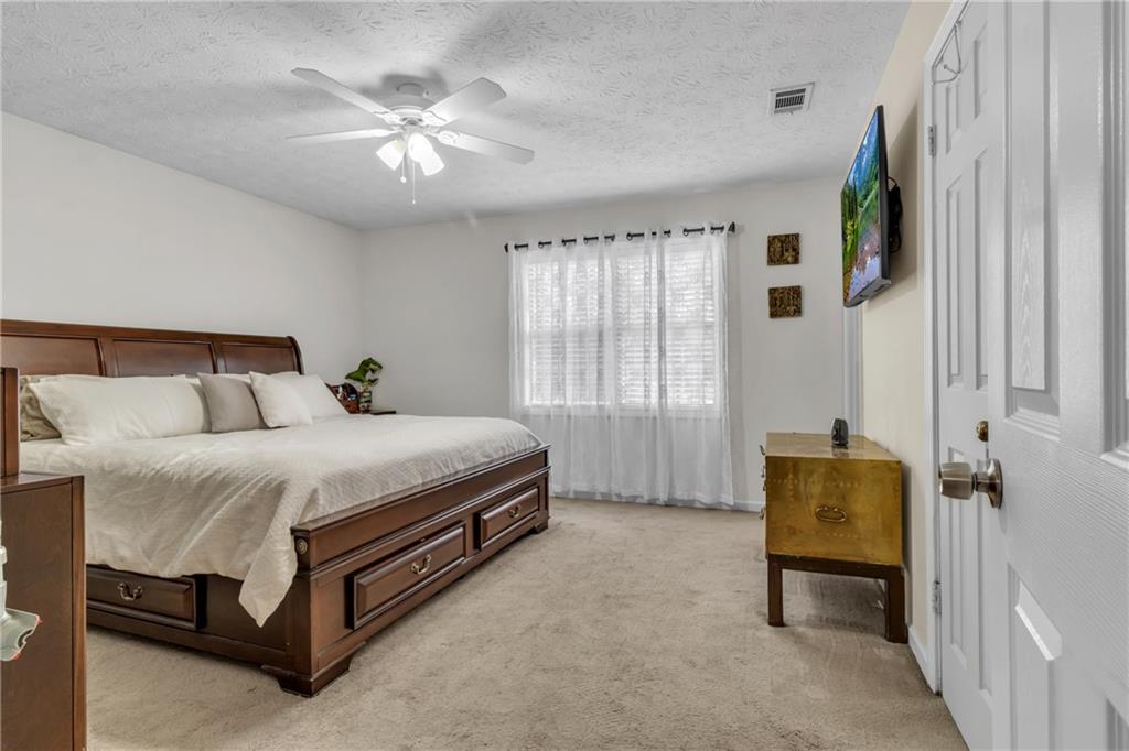 3123 Booths Court Dacula, GA 30019 - Photo 19 of 56 a bedroom with a bed and a chandelier