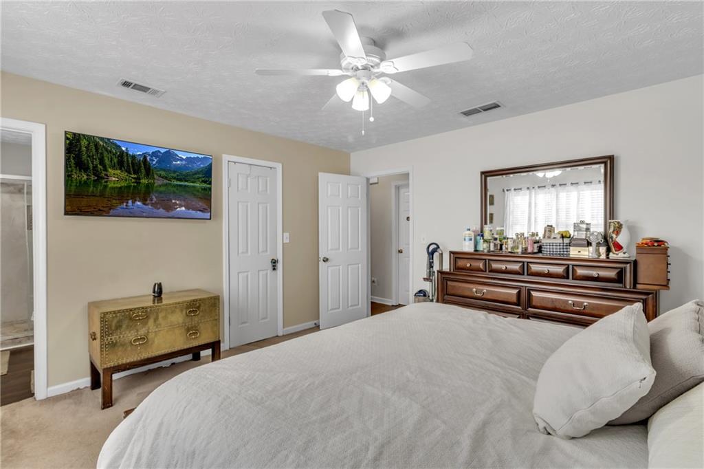 3123 Booths Court Dacula, GA 30019 - Photo 21 of 56 a bedroom with a bed and a chandelier