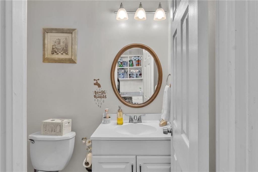 3123 Booths Court Dacula, GA 30019 - Photo 32 of 56 a bathroom with a toilet a sink and a mirror