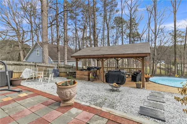 a view of a house with wooden deck and furniture