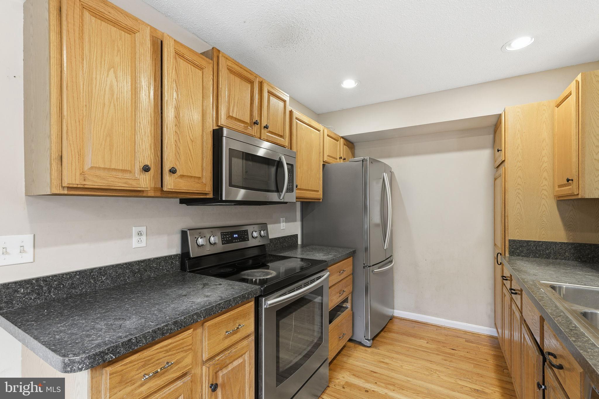 110 Rugby Place Winchester, VA 22603 - Photo 9 of 41 a kitchen with stainless steel appliances granite countertop a refrigerator a stove and a sink with wooden floor