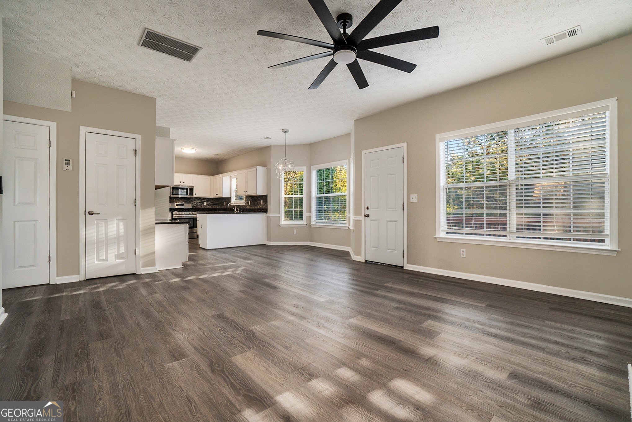 4395 Celebration Drive Southwest Atlanta, GA 30331 - Photo 7 of 25 a view of a kitchen with a stove cabinets a ceiling fan and wooden floor