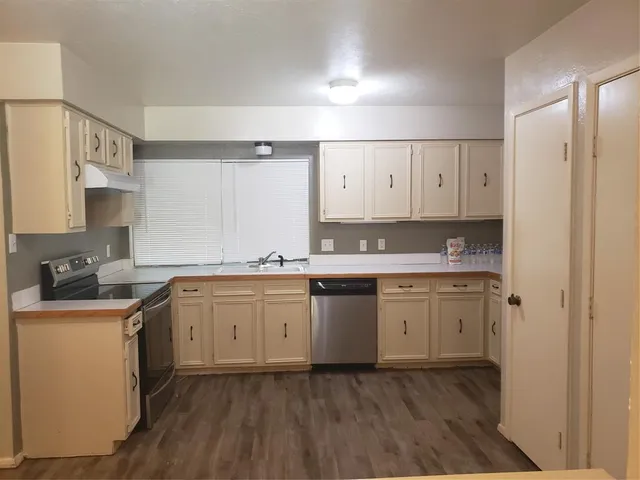 a kitchen with granite countertop cabinets stainless steel appliances and a sink