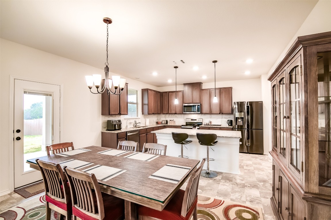 1924 Stringer Pass Leander, TX 78641 - Photo 13 of 34 a view of a dining room and livingroom with furniture wooden floor a chandelier