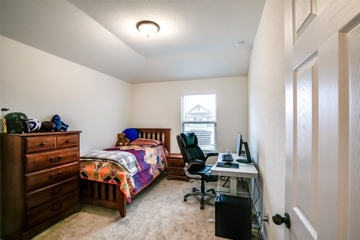1924 Stringer Pass Leander, TX 78641 - Photo 28 of 34 a bedroom with a bed and a table in it