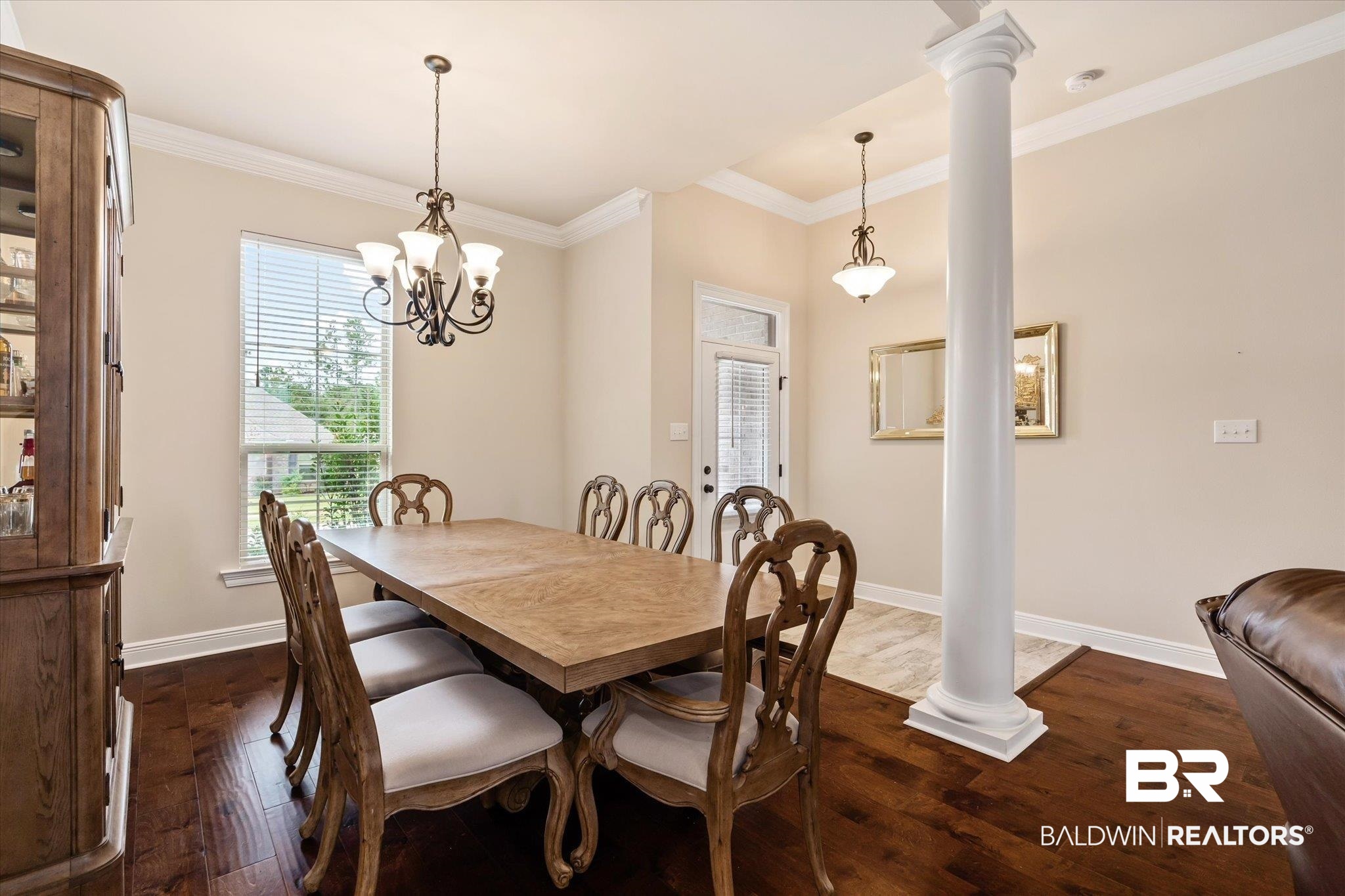 1786 Vivace Drive Foley, AL 36535 - Photo 4 of 21 Dining space featuring ornate columns, dark wood-style flooring, ornamental molding, and a chandelier