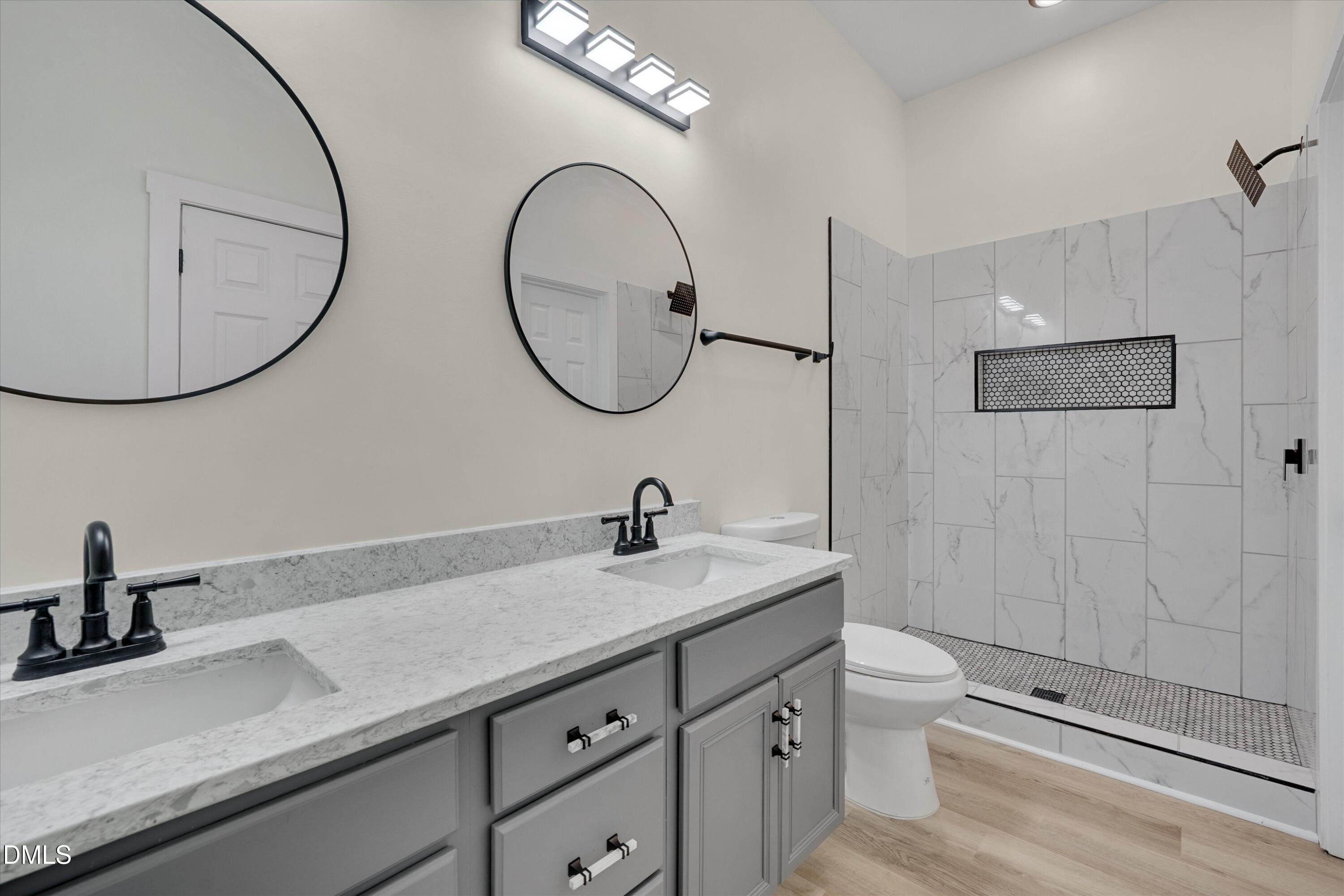 111 Virginia Avenue Roxboro, NC 27573 - Photo 19 of 42 a bathroom with a granite countertop toilet a sink and a mirror