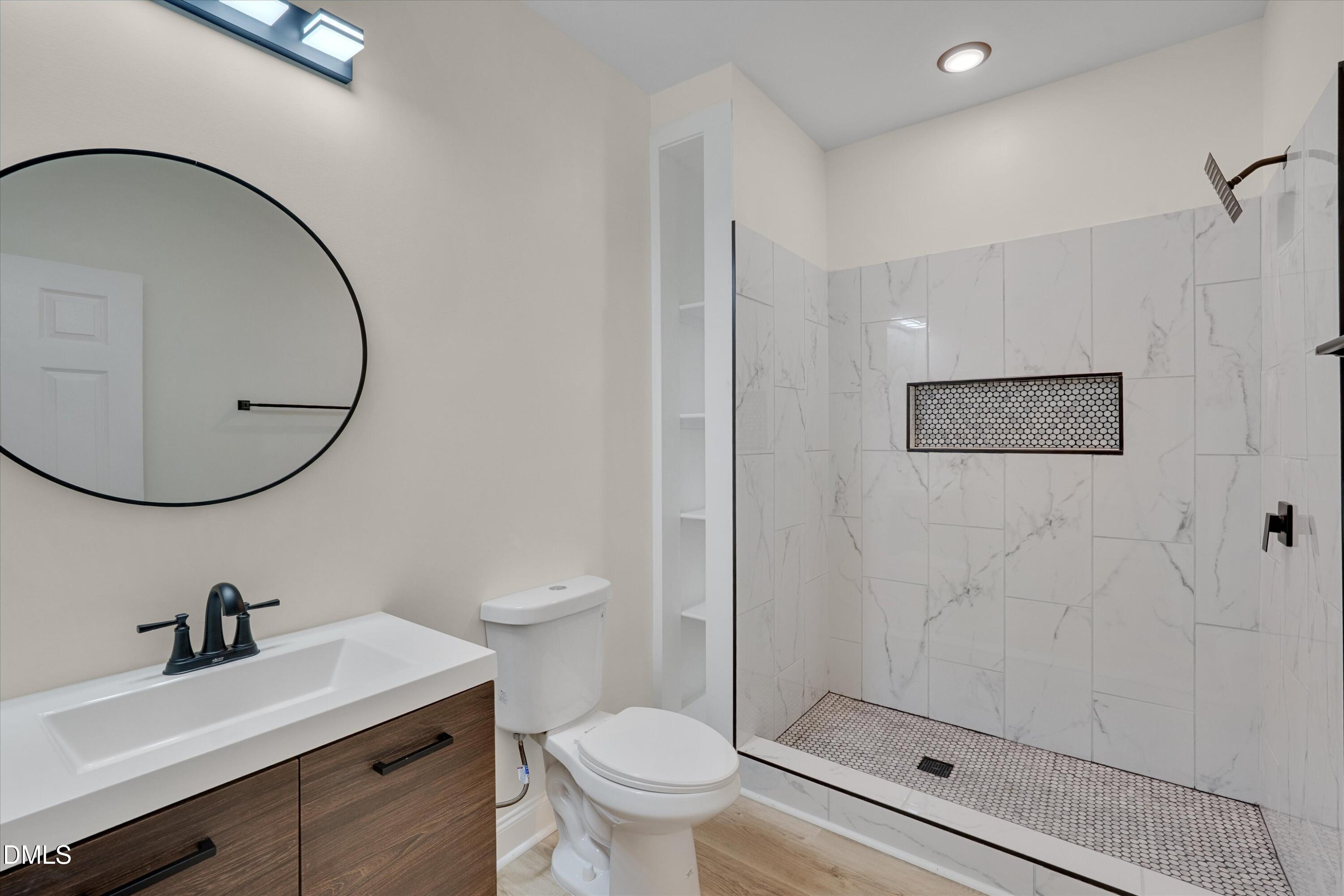 111 Virginia Avenue Roxboro, NC 27573 - Photo 22 of 42 a bathroom with a sink a toilet and a mirror