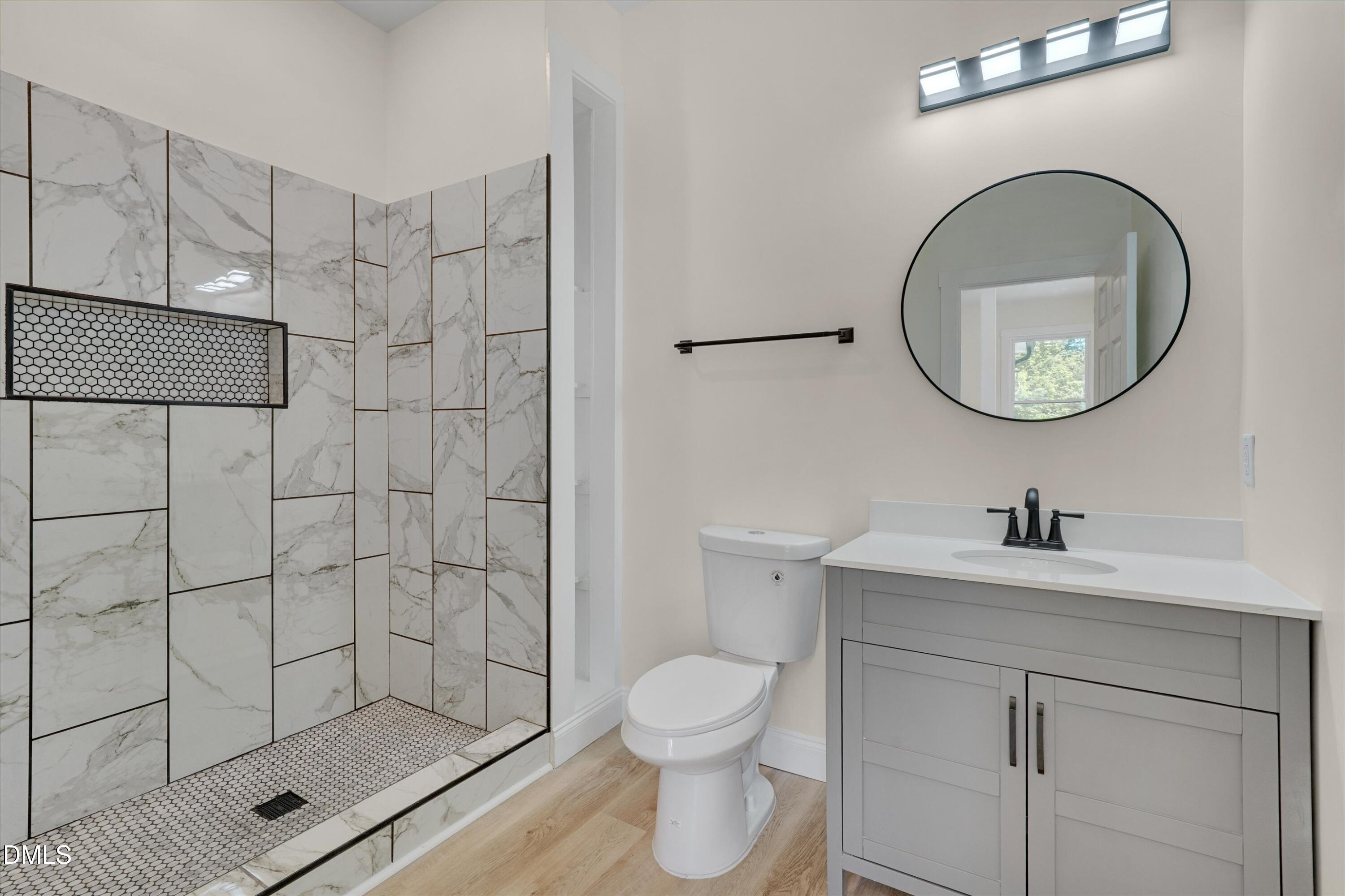 111 Virginia Avenue Roxboro, NC 27573 - Photo 25 of 42 a bathroom with a toilet sink vanity and shower