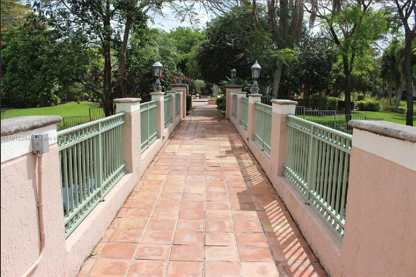 12136 St.Andrews Place, Unit 205 Miramar, FL 33025 - Photo 14 of 23 a view of a pathway with a wrought fence
