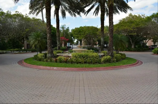 front view of a house with a yard and palm trees