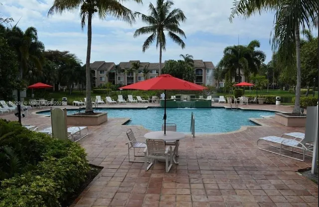 a patio with a table and chairs under an umbrella