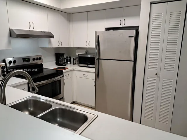 a kitchen with stainless steel appliances a refrigerator and a sink