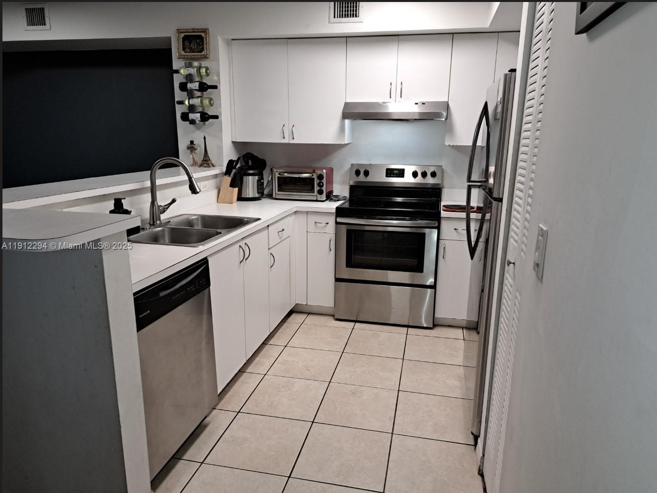 12136 St.Andrews Place, Unit 205 Miramar, FL 33025 - Photo 5 of 23 a kitchen with stainless steel appliances a stove a sink and a refrigerator