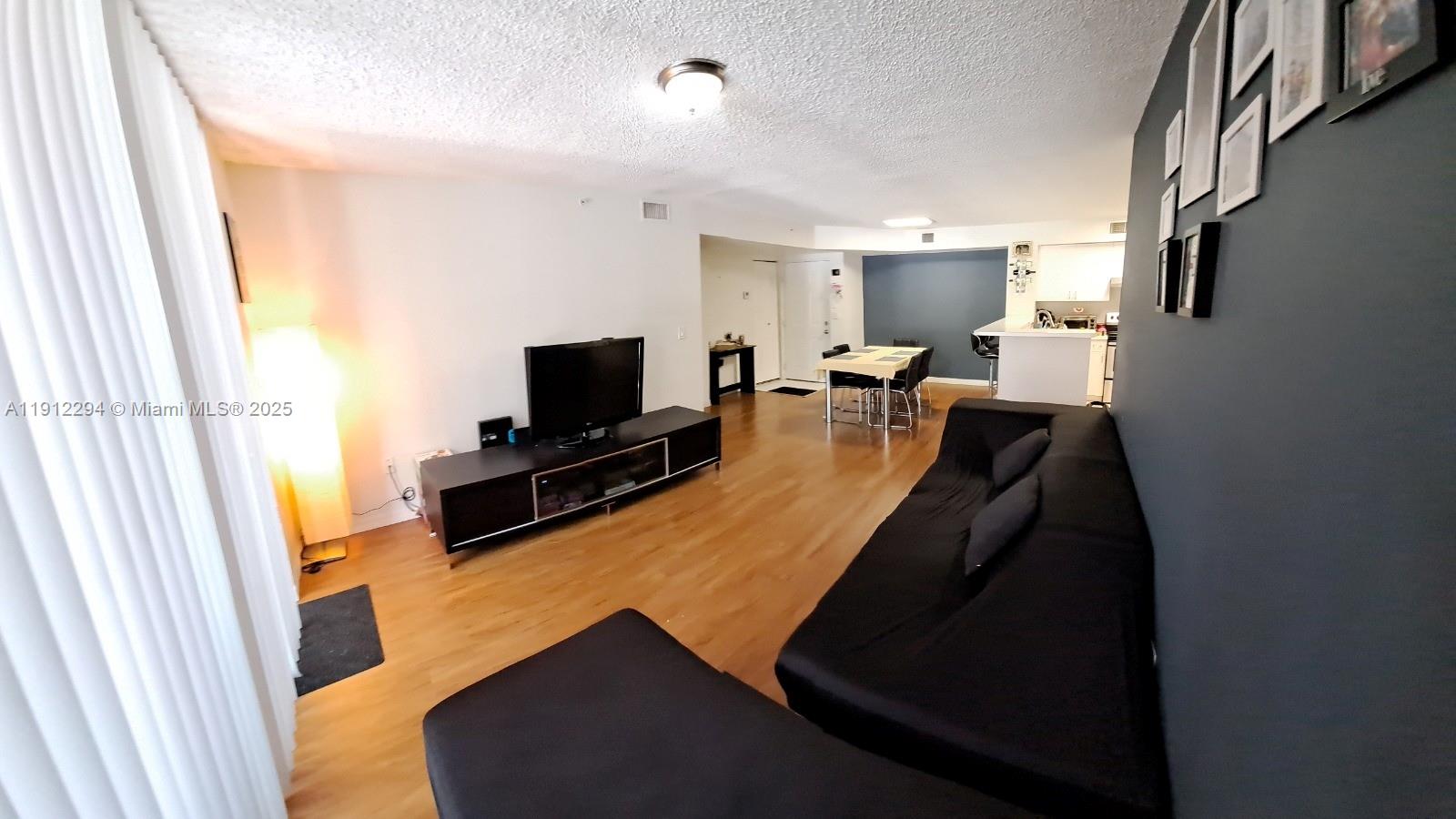 12136 St.Andrews Place, Unit 205 Miramar, FL 33025 - Photo 6 of 23 a living room with furniture and a flat screen tv