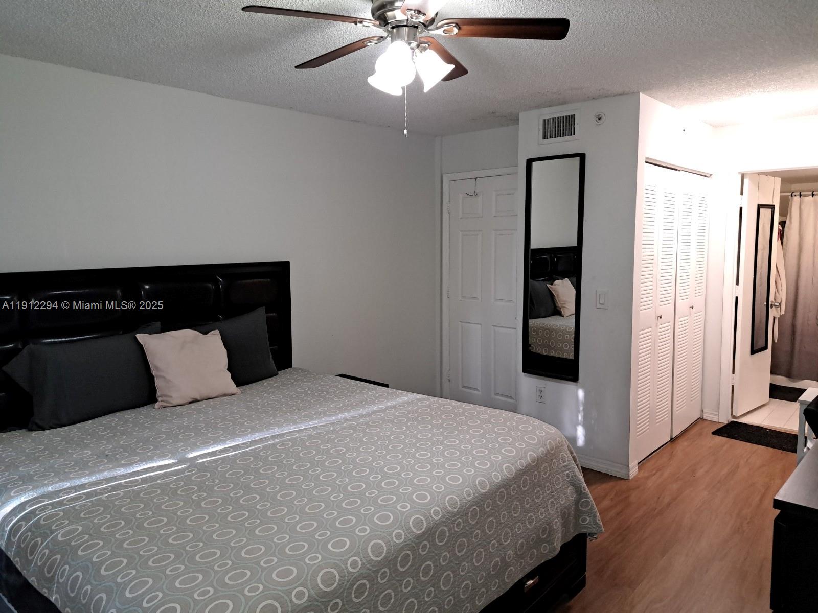 12136 St.Andrews Place, Unit 205 Miramar, FL 33025 - Photo 9 of 23 a bedroom with a large bed and a chandelier