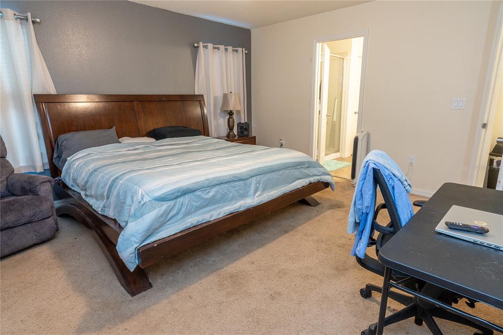 4563 Orchard Grove Road St. Cloud, FL 34772 - Photo 24 of 51 a bedroom with a bed and a desk