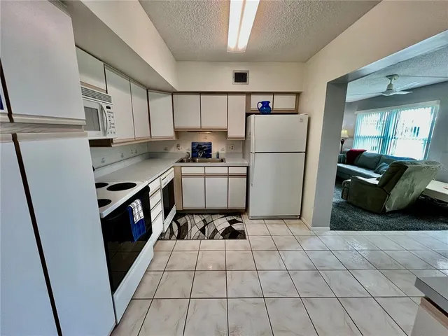 a kitchen with granite countertop a refrigerator and a sink