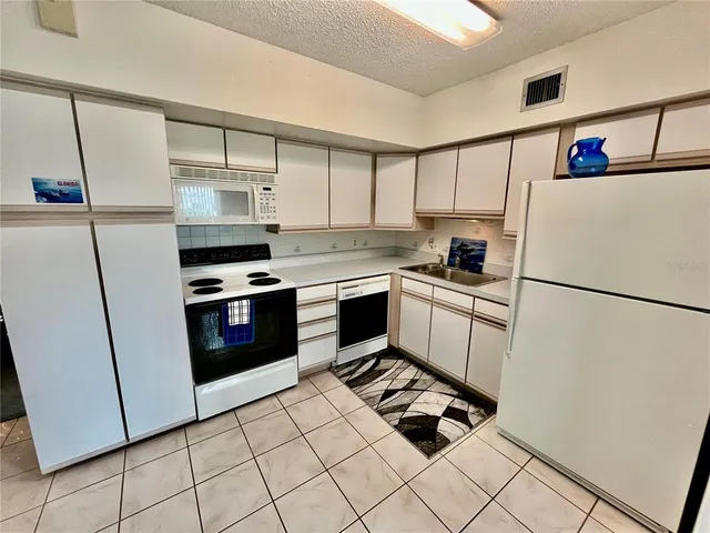 a kitchen with cabinets and white appliances