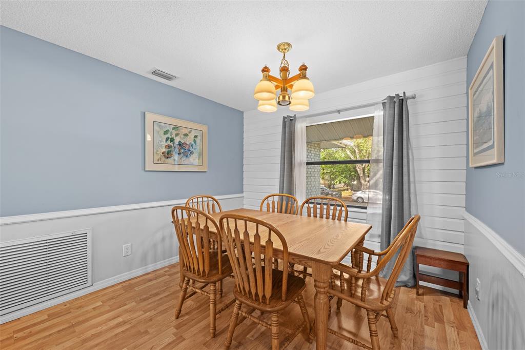 140 Valley Circle Brandon, FL 33510 - Photo 11 of 48 a view of a dining room with furniture a chandelier and wooden floor
