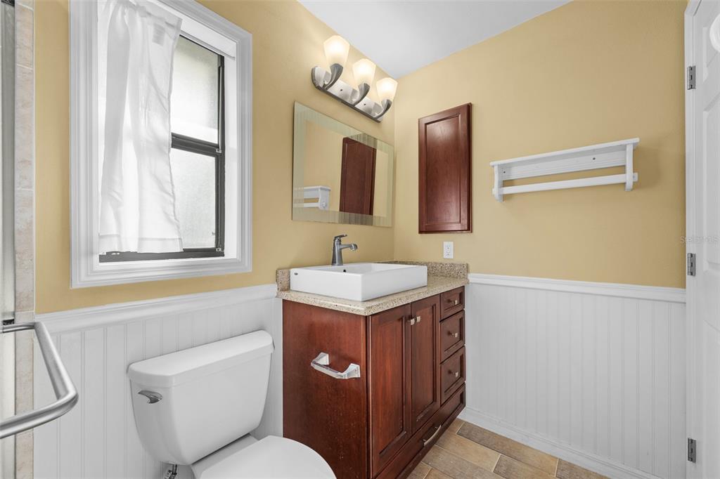 140 Valley Circle Brandon, FL 33510 - Photo 35 of 48 a bathroom with a toilet a sink a mirror a window and vanity