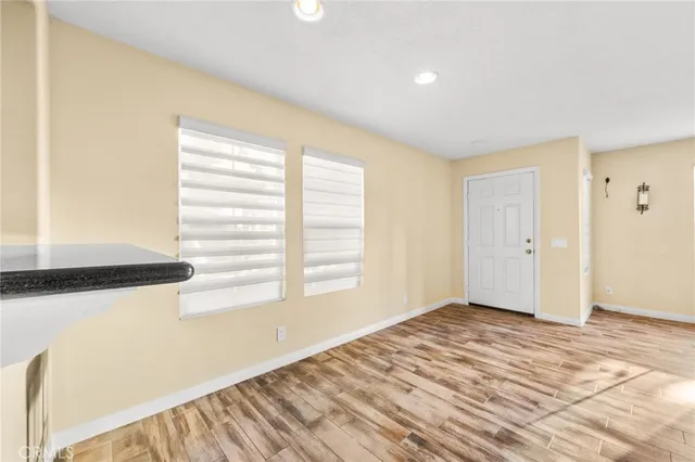 a kitchen with stainless steel appliances granite countertop wooden cabinets a stove top oven a sink and dishwasher with wooden floor