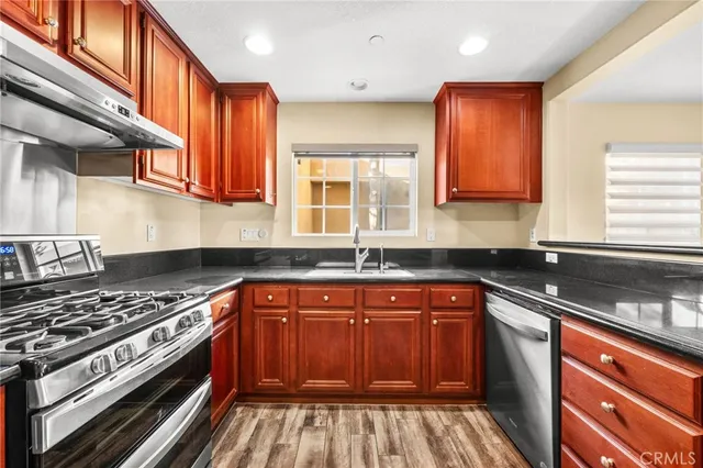 a view of a kitchen with wooden floor and a window