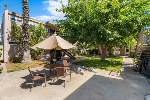 a view of a backyard with table and chairs under an umbrella