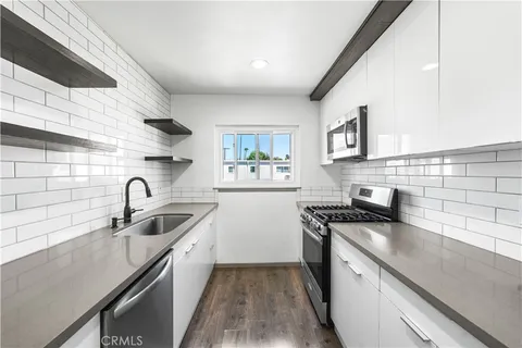 a kitchen with stainless steel appliances granite countertop a sink stove and cabinets