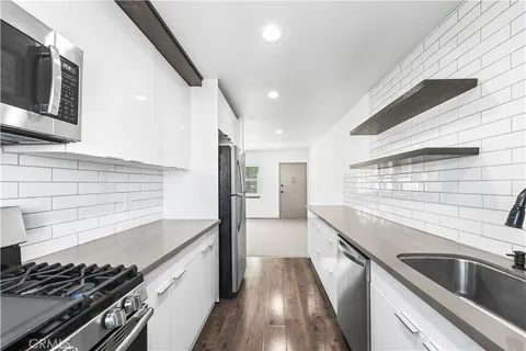 a kitchen with stainless steel appliances granite countertop a sink and a stove
