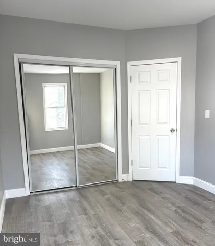 an empty room with window and mirror