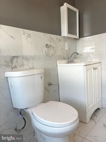 a bathroom with a sink a toilet and mirror