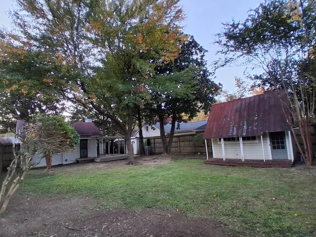 a view of a house with a yard tree and tree
