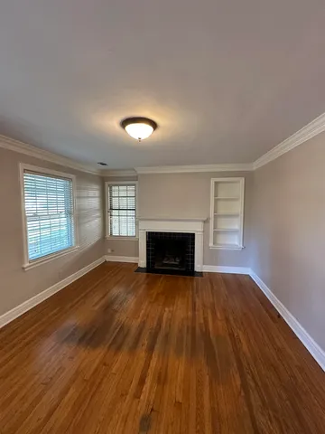 an empty room with wooden floor and fireplace