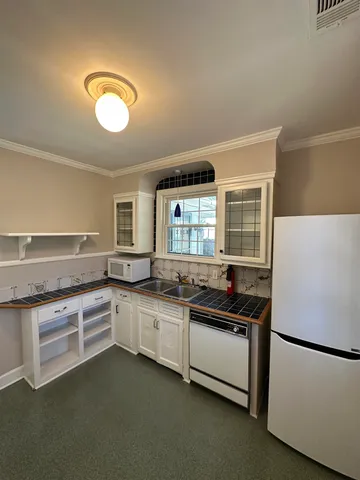 a kitchen with white cabinets and a sink
